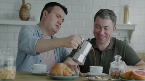 two men enjoying a coffee and breakfast in the kitchen