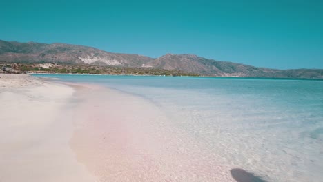 Mädchen,-Das-Am-Rosafarbenen-Strand-Läuft,-Vorne-Eine-Lagune