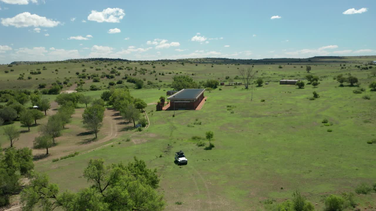 Aerial of jeep standing in green grassy field, travel South Africa, open plains