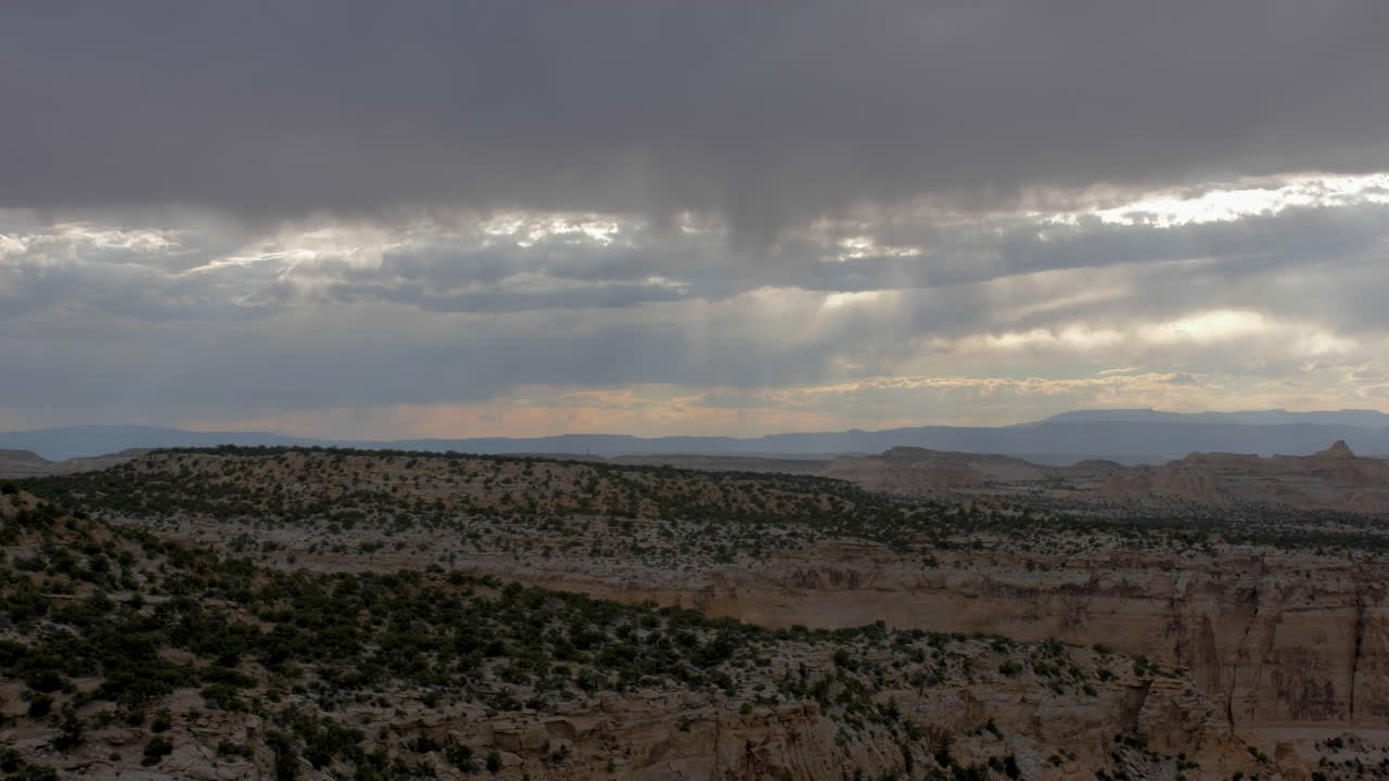 Ripresa con zoom e panoramica di un canyon desertico con vista su formazioni rocciose e mesa