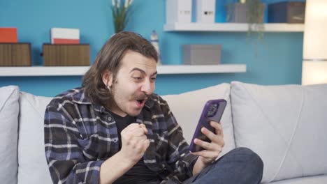 el hombre que está contento con lo que ve en el teléfono. estado de alegría.