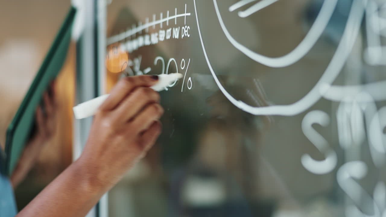 A person writing on a glass surface