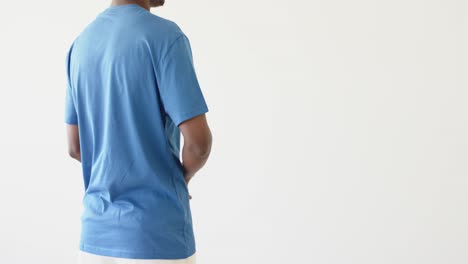 midsection of african american man wearing blue t-shirt with copy space on white background