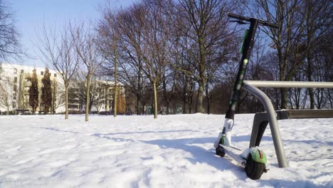 Electric-scooter-abandoned-in-the-park-during-snowy-winter-static-shot