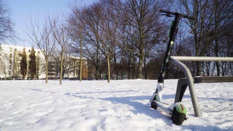 scooter eléctrico abandonado en el parque durante el tiro estático de invierno nevado