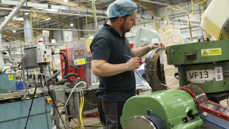 worker operating industrial machinery in a production plant