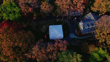 halloween neighborhood gathering with an inflatable tent surrounded by colorful fall trees.