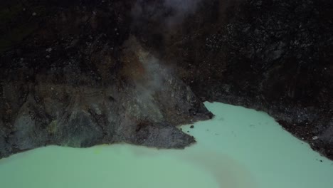 vista superior del famoso cráter blanco kawah putih con vapor que se eleva desde un respiradero en bandung, java occidental, indonesia - toma aérea de un dron