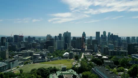 4K-Cinematic-urban-drone-footage-of-an-aerial-view-of-buildings-and-skyscrapers-in-the-middle-of-downtown-Montreal,-Quebec-on-a-sunny-day