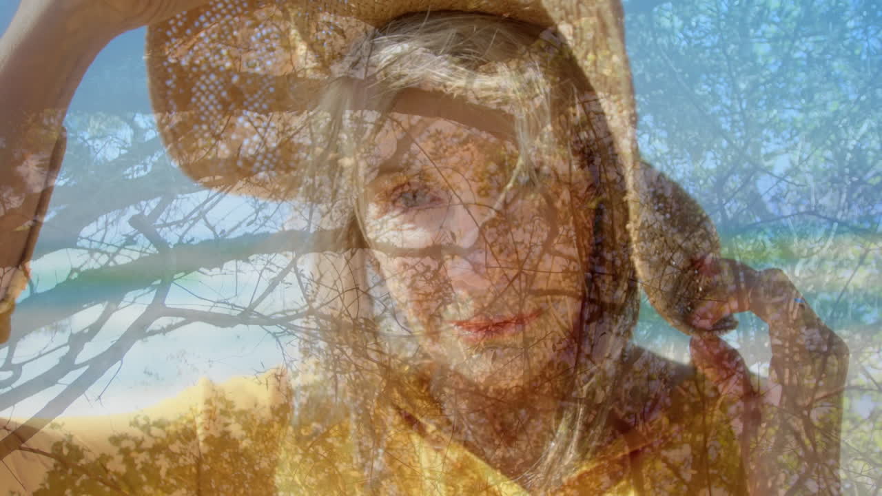 Animation of trees over happy caucasian senior woman in hat