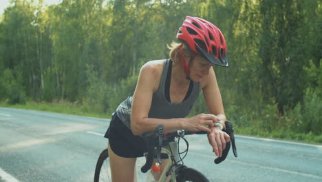 female cyclist having break on road