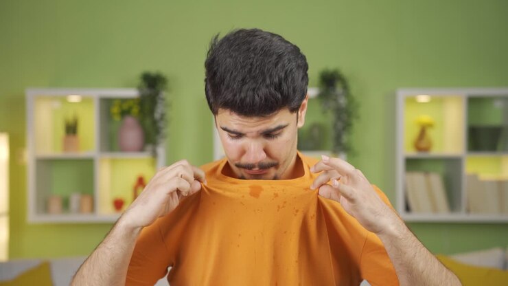 Giovane uomo che suda e si sente soffocare per il caldo estivo