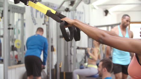 mujer joven haciendo ejercicio de peso corporal en un gimnasio ocupado