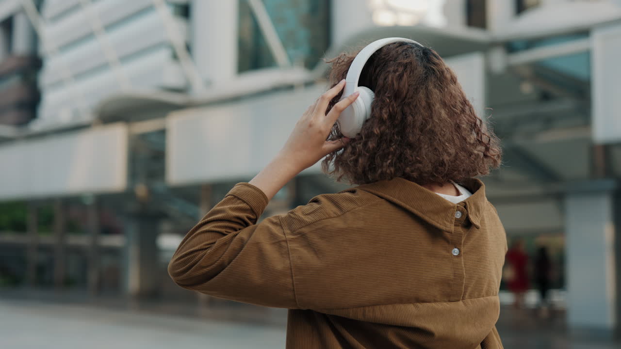 Mulher ouvindo música na cidade