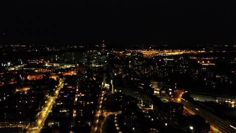 A-smooth,-approaching-and-descending-aerial-shot-on-Helinski,-Finland-as-a-train-passes-through-the-city-in-the-distance