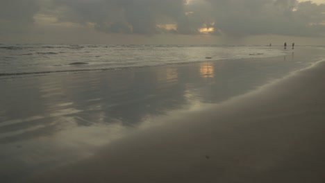 Es-Entfaltet-Sich-Eine-Ruhige-Strandszene,-Während-Die-Sanften-Meereswellen-Rhythmisch-Das-Ufer-Streicheln