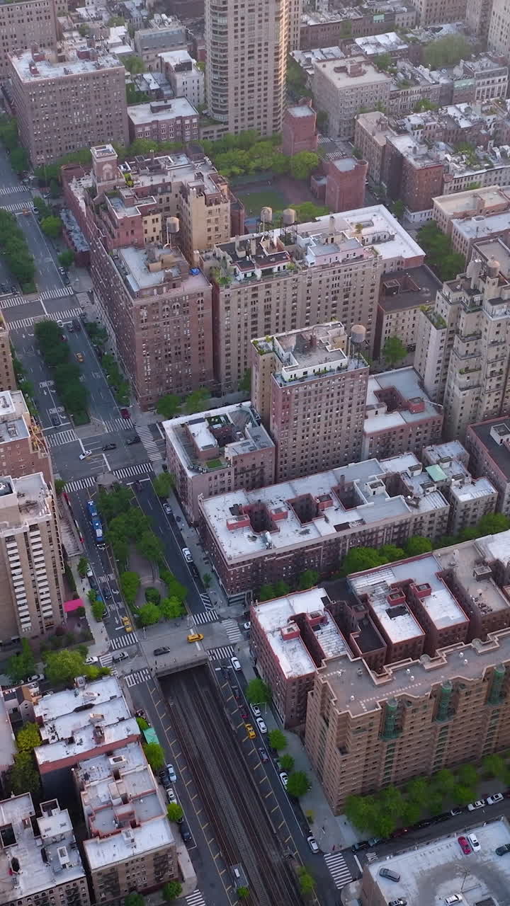 Multi-storied buildings of densely-built quarters of metropolis. Busy city at daytime. Aerial perspective. Vertical video