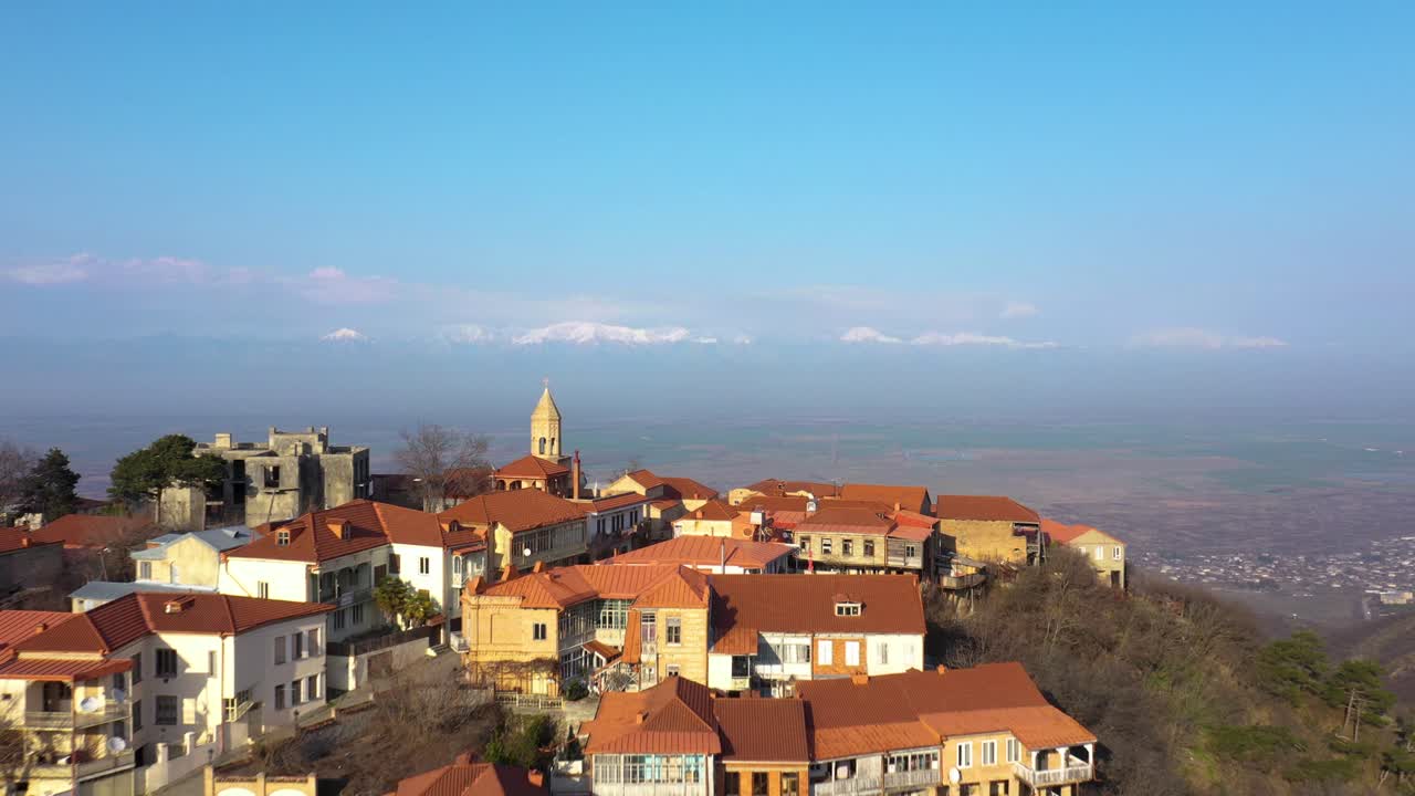 Splendida vista aerea di un pittoresco villaggio in cima a una collina con montagne sullo sfondo