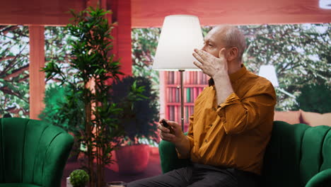 Elderly man applying serum and moisturizing cream on his cheeks