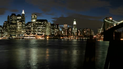 Langsamer-Schwenk-Einer-Zeitrafferaufnahme-Von-Wolken-In-Rosa--Und-Violetttönen,-Die-Bei-Einbruch-Der-Dunkelheit-über-Die-Skyline-Von-New-York-City-Ziehen