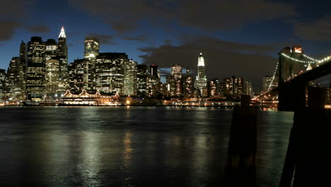 slow pan of a timelapsed shot of clouds in shades of pink and purple passing over the new york city skyline as darkness falls