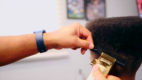 peluqueros acabado a mano corte de pelo de niños negros con recortadora sobre peine