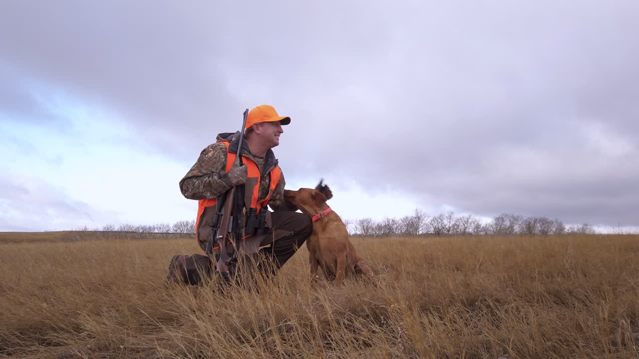 En jeger med rifle går på jakt med hunden sin i villmarken i Saskatchewan, Canada – totalbilde