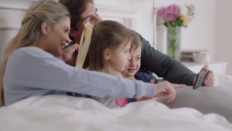 Familia-Feliz-Usando-Un-Teléfono-Inteligente-En-La-Cama,-Madre-Y-Padre-Con-Niños-Viendo-Entretenimiento-Jugando-Juegos-En-El-Teléfono-Móvil-Divirtiéndose-Juntos-El-Fin-De-Semana-Por-La-Mañana,-Imágenes-De-4k