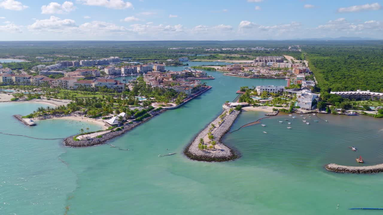 Marina Cap Cana a její okolní obytná oblast. Tyrkysové Karibské moře se setkává s nedotčeným pobřežím. Ideální pro luxusní cestování a nemovitosti, Dominikánská republika. Letecký pohled dozadu
