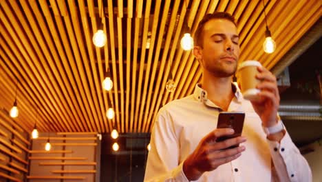 male executive using mobile phone while having coffee 4k