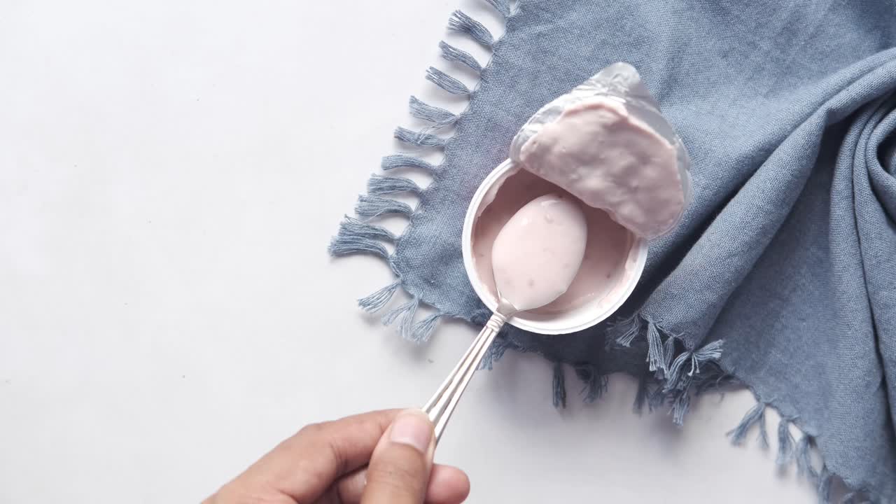 yogur rosa en un recipiente con cuchara