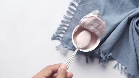 yogur rosa en un recipiente con cuchara