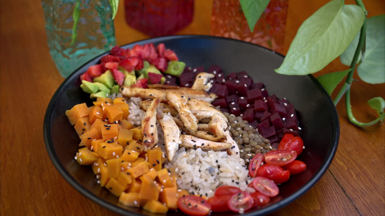 dolly en un tiro de un cuenco saludable de alta proteína con batatas dulces, remolachas, lentejas, arroz, pecho de pollo y tomates