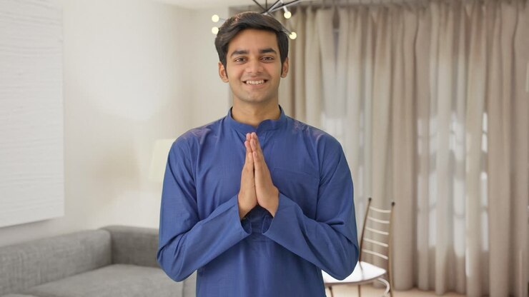 un chico indio lindo haciendo namaste