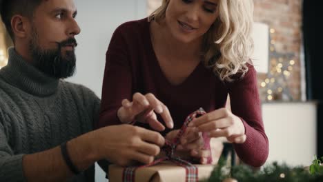 pareja feliz empaquetando regalos de navidad