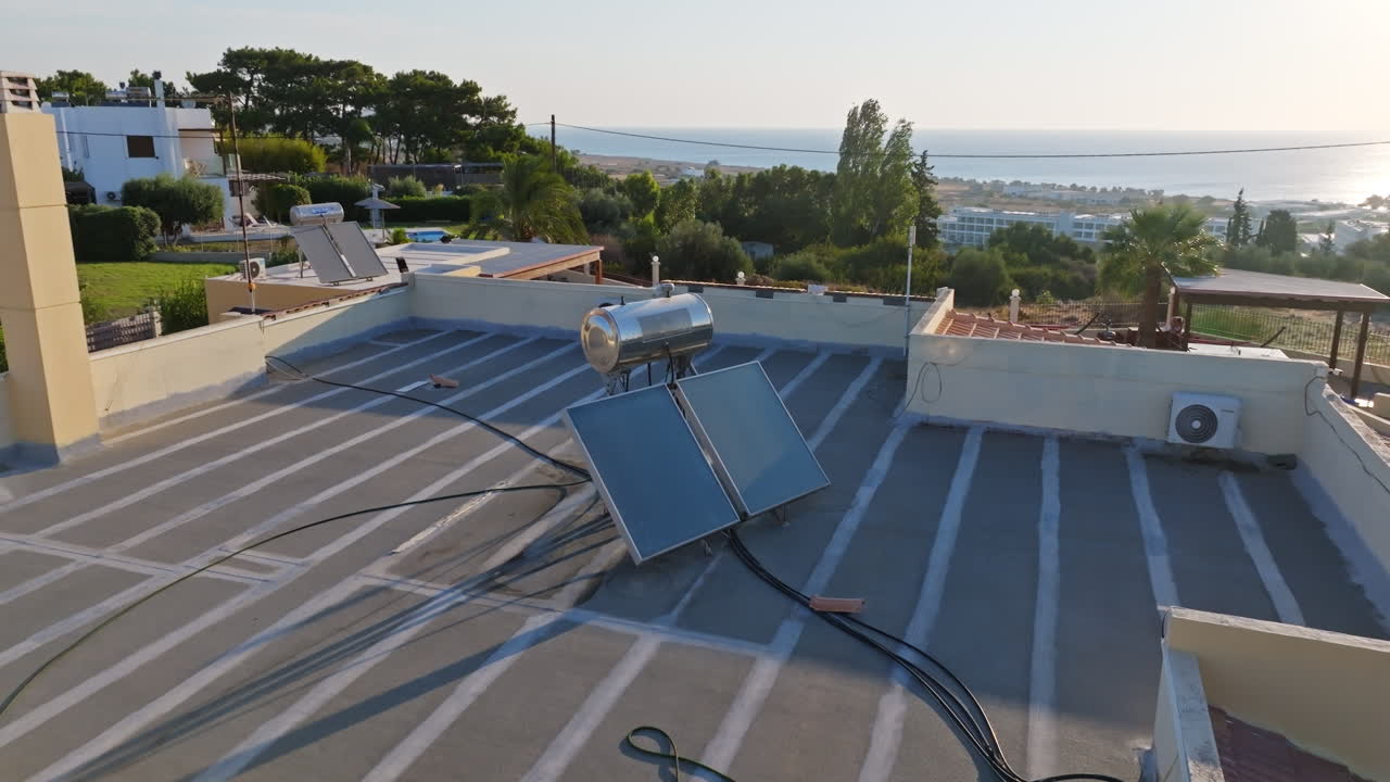Aerial view circling a solar panel heating the water of a villa in Greece, sunset