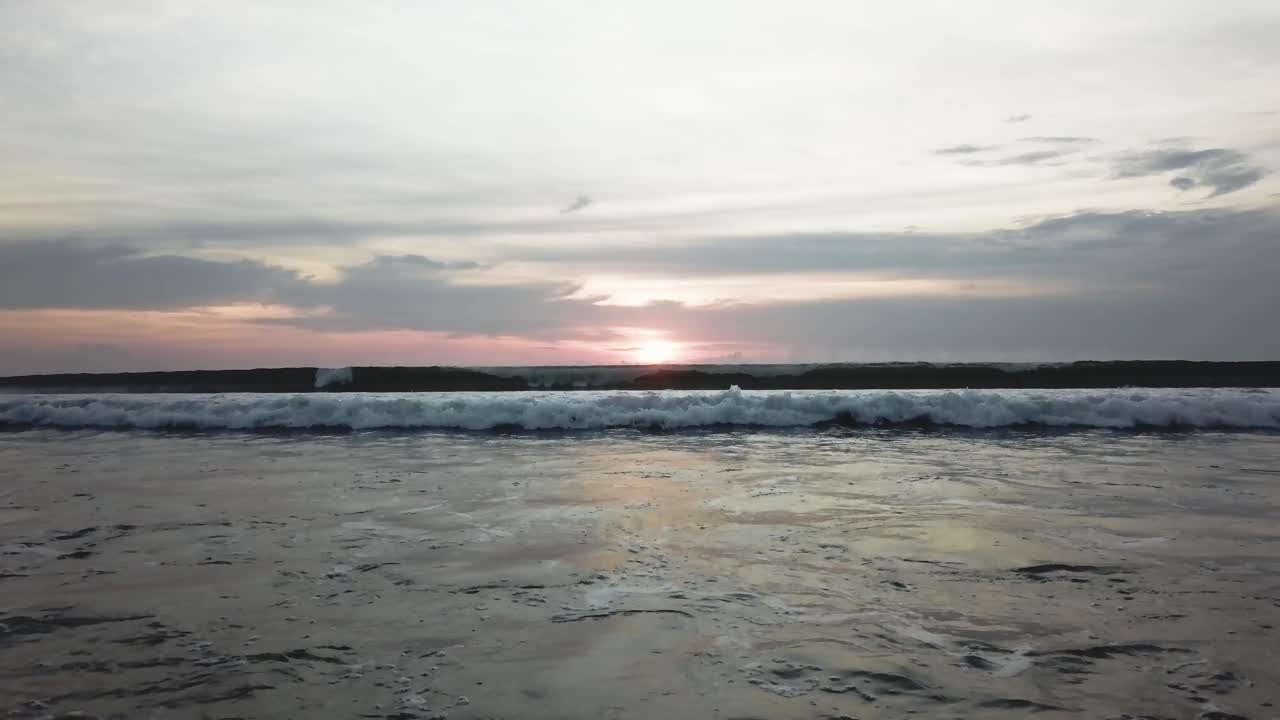 puesta de sol en la playa con surfistas