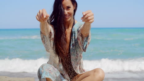 pretty lady sitting at the beach holding sand