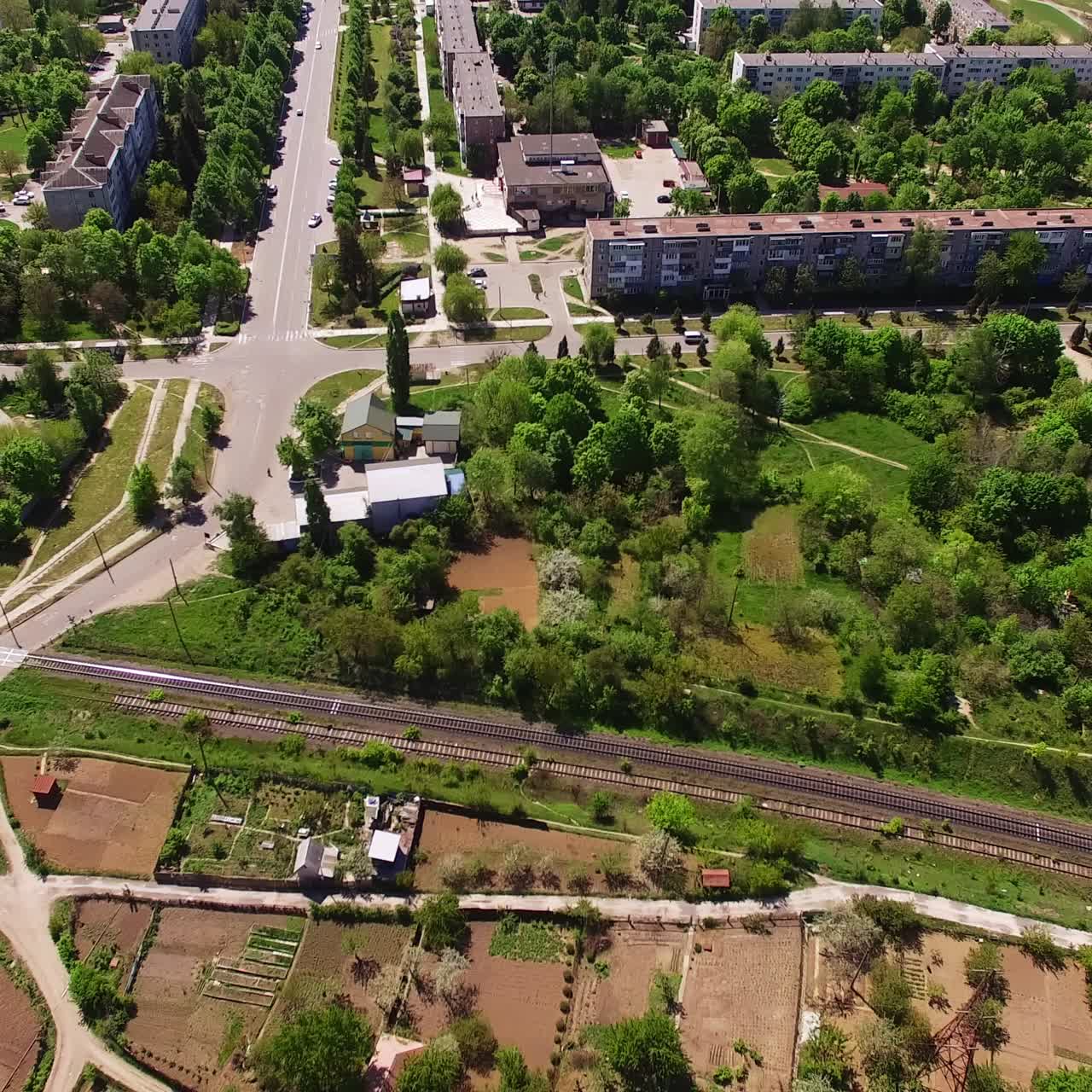 Sunny city scenery neighboring with green forest massif. Beautiful urban city panorama on clear sunny daytime. Top view