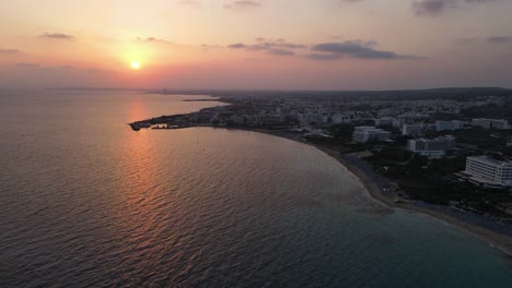 beautiful areal view of the mediterranean sea and glowing sunset, warm orange summer evening over calm sea in ayia napa cyprus 4k