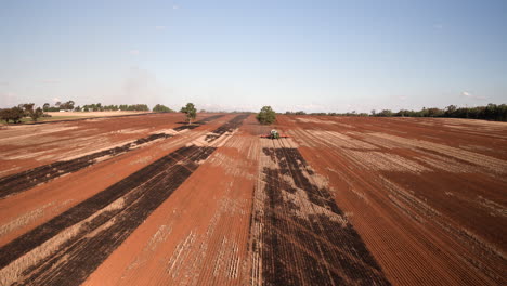 vista aérea de drones volando hacia maquinaria agrícola en un campo grande remolcando sembradoras de trigo sembrando semillas para cultivos en la ciudad rural de wagga wagga nsw australia