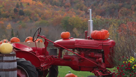 Impresionante-Foto-Estacional-De-Calabazas-Sentadas-En-Un-Tractor-Rojo