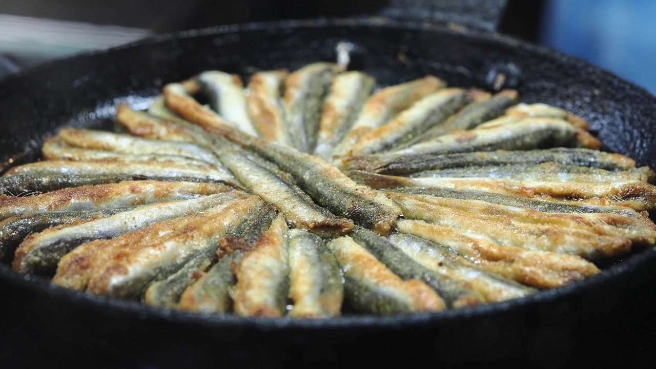 Anchovas Frescas Fritando em uma Frigideira de Ferro Fundido Quente
