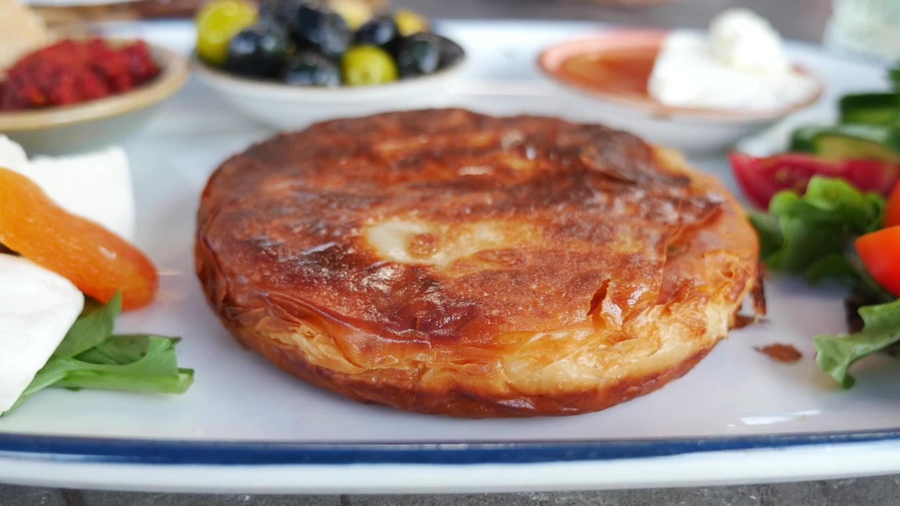 Traditional Turkish Breakfast Plate with Crispy Pastry and Sides