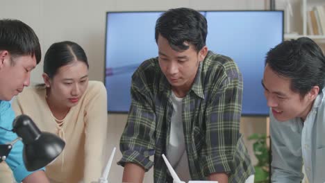 풍력 터빈과 함께 아시아 엔지니어 그룹의 클로즈업은 사무실에서 노트북 작업에 대해 논의합니다.