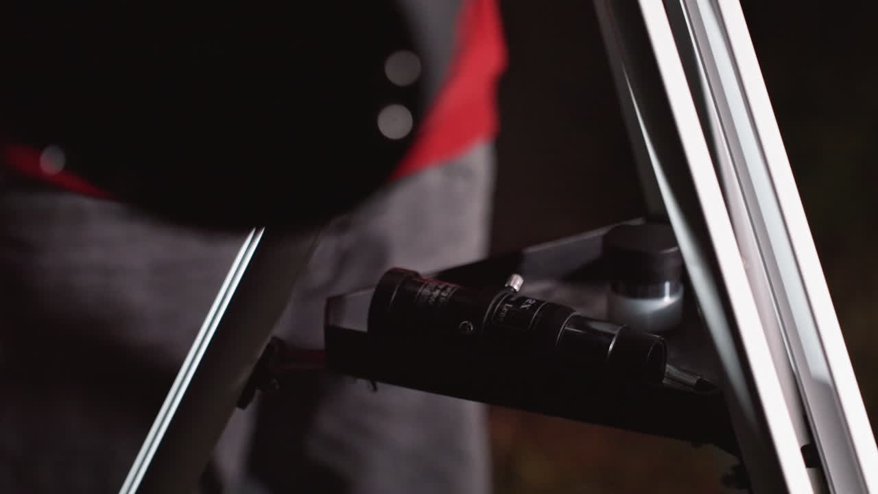 closeup hand attaching telescope eyepiece on tripod shelf at night amateur astronomer prepares equipment, aligns lens, finetunes focus and mount, soft bokeh lights in background, calm anticipation