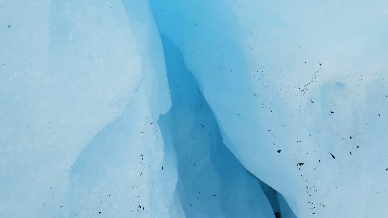 melting glacier drips over ice crevasse