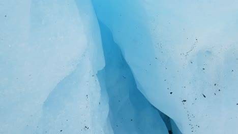 melting glacier drips over ice crevasse