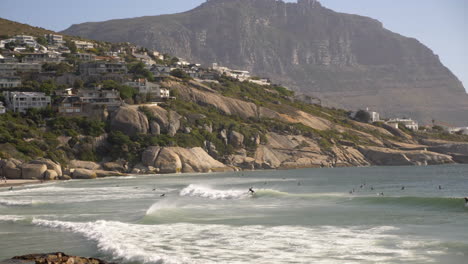 surfers riding waves in cape town south africa at sunrise