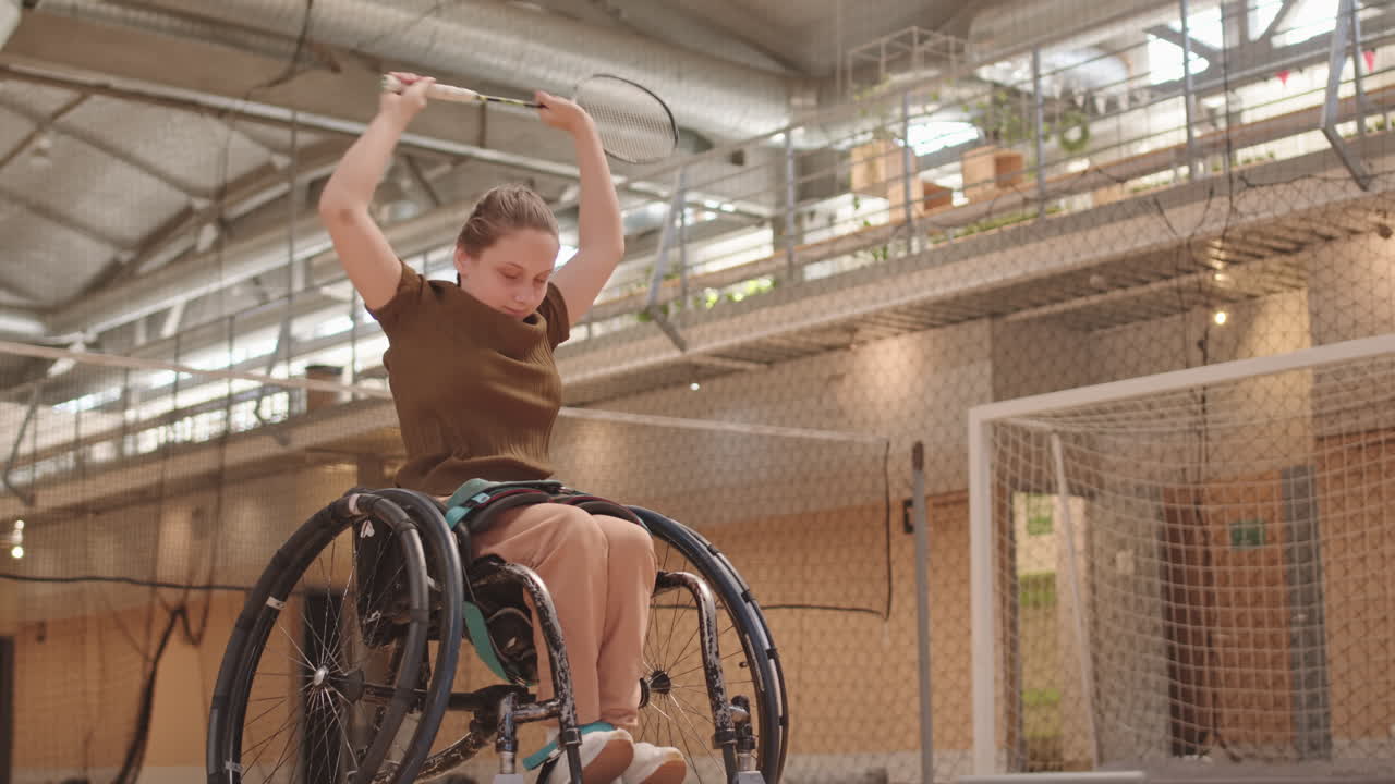 Girl in Wheelchair Warming Up Before Badminton Training